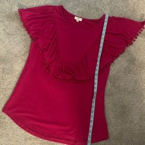 Fuchsia top with pompom details.  60% cotton 40%polyester